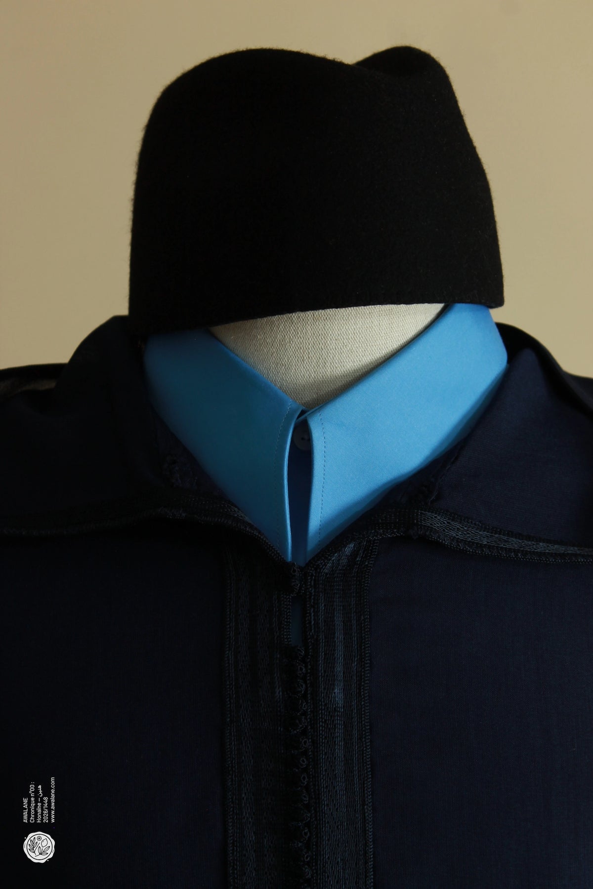Coiffe noire et col bleu ciel sur une djellaba homme bleu marine, capuche pointue rabattue