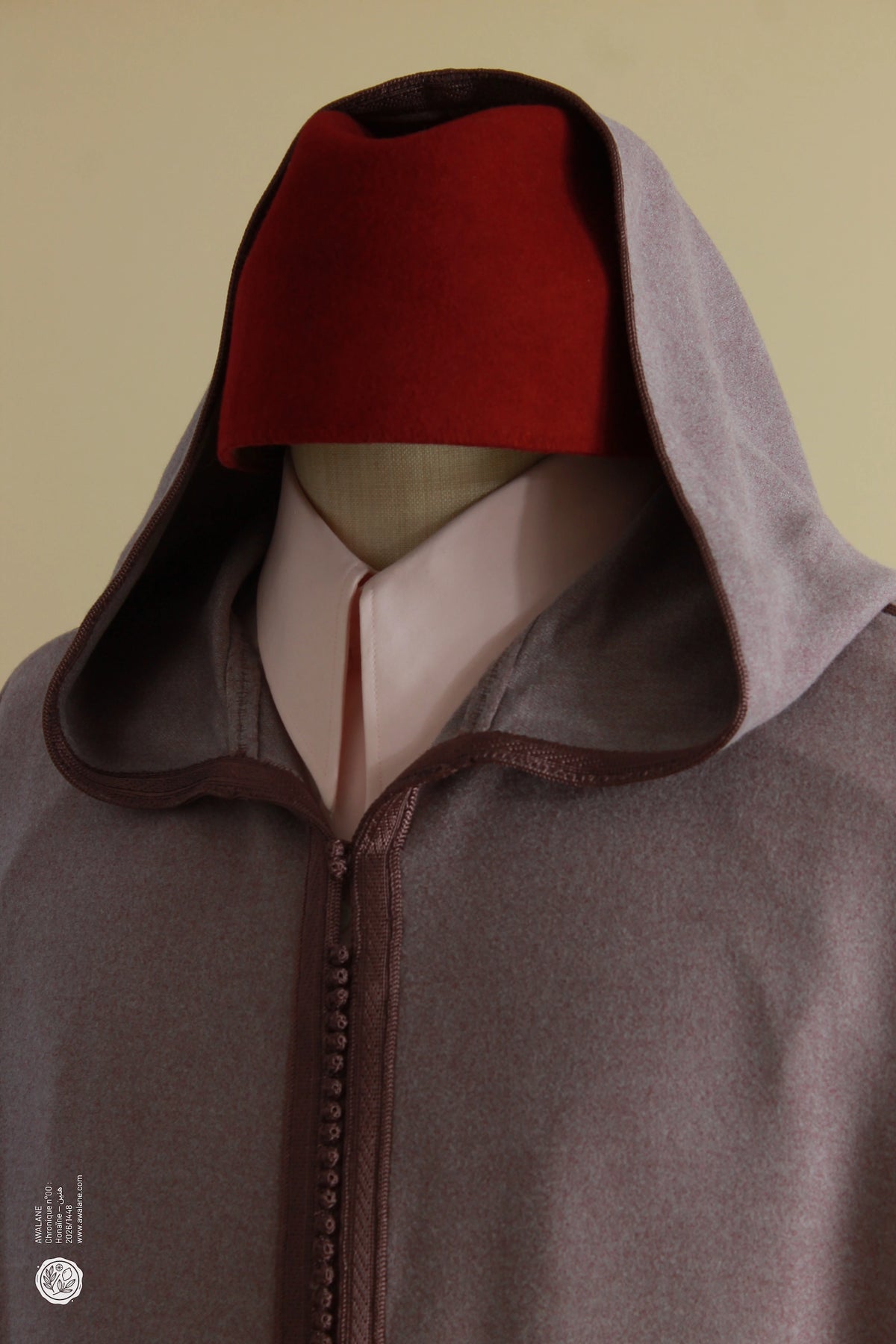 Tarbouche rouge sous la capuche relevée d'une djellaba homme mauve en laine